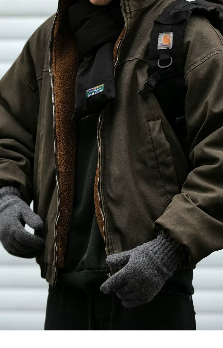 Person wearing a brown jacket with a visible brand logo, black gloves, and a black backpack against a white background.