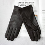 Pair of black leather gloves on a magazine with 'Santa Barbara United States' text.
