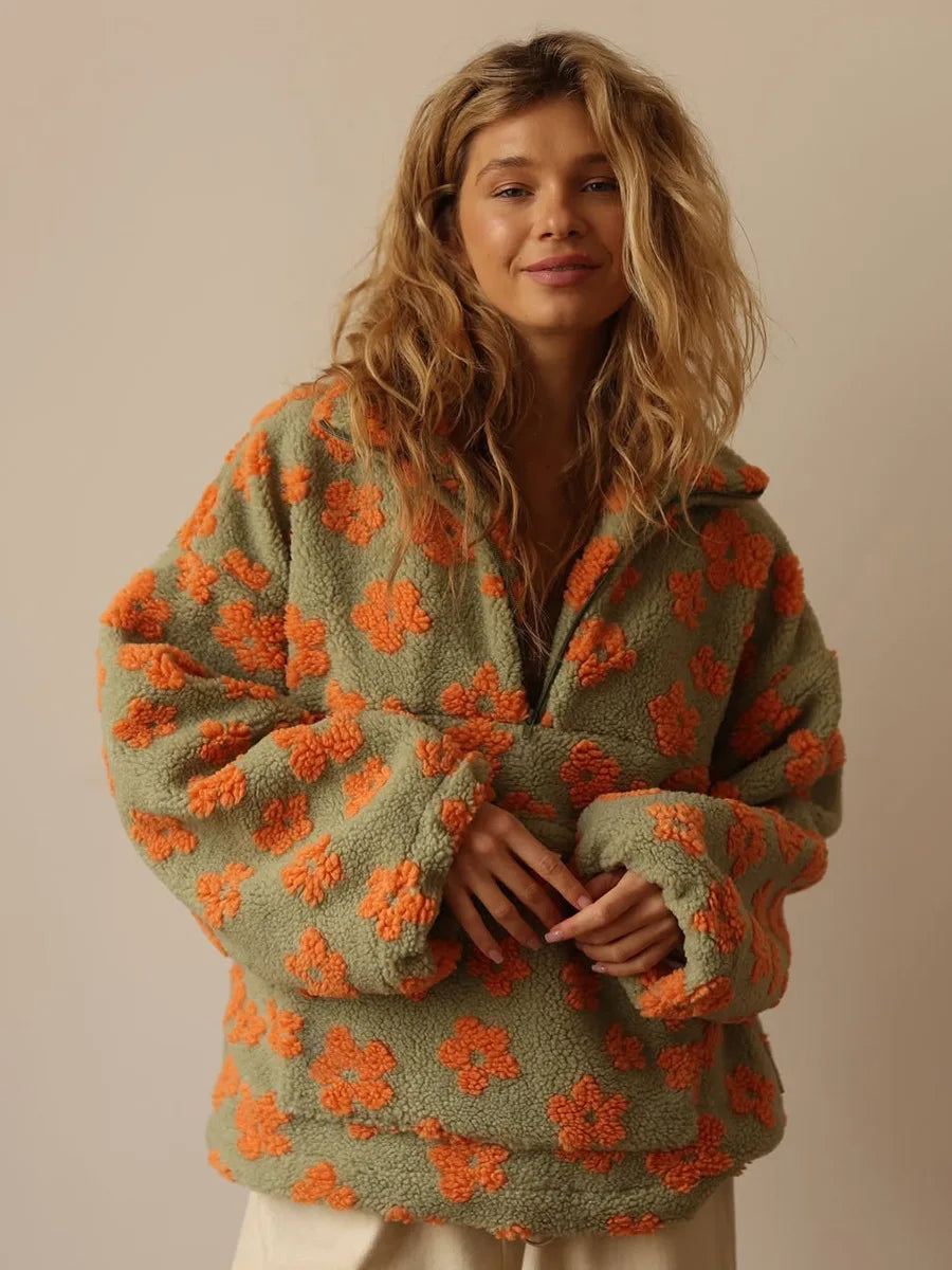 Woman wearing a green and orange floral-patterned sweater against a beige background