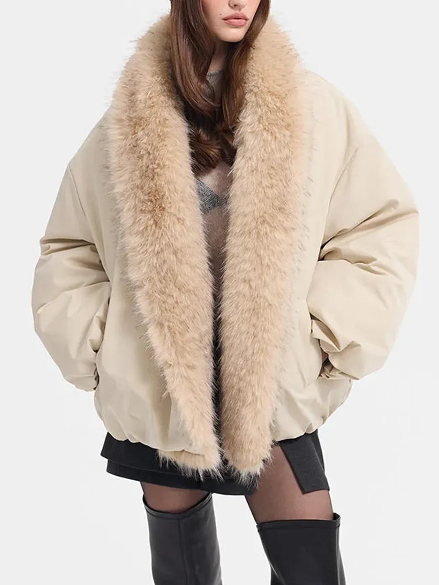 A model wearing a beige puffer jacket with a large, fluffy beige faux-fur collar, styled with a black mini skirt and black knee-high boots against a plain white background.