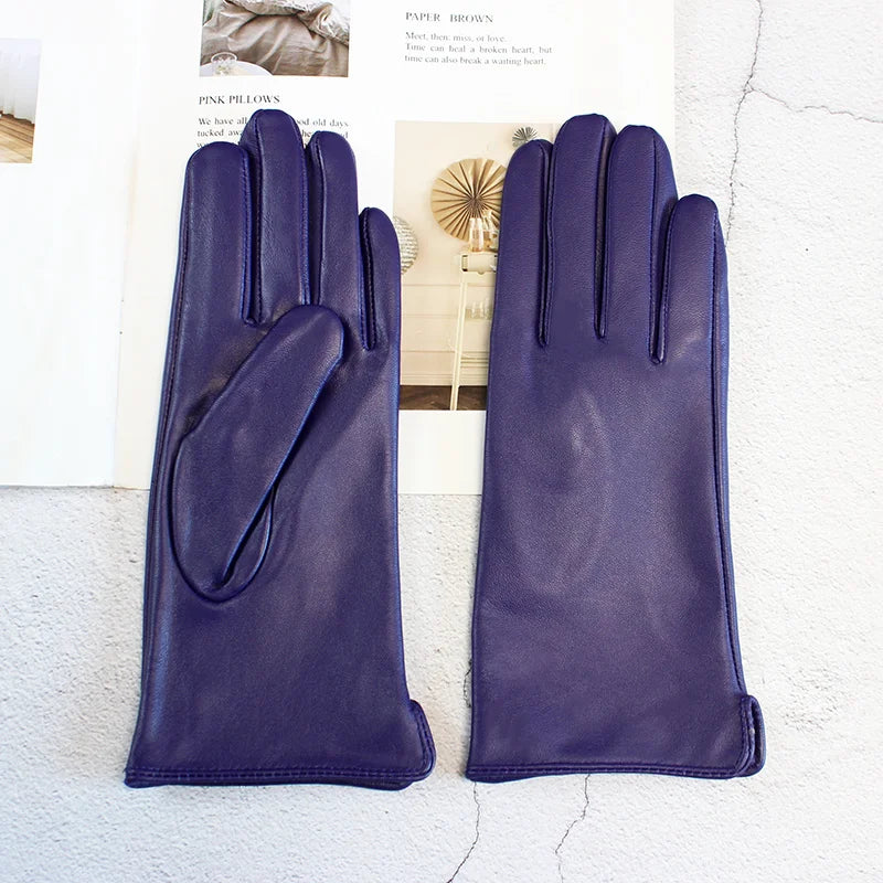 Pair of purple gloves on a textured surface with a blurred background