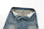 A close-up of folded light-to-medium wash blue denim jeans showing the waistband, button closure, inner lining, and interior tags against a plain white background.