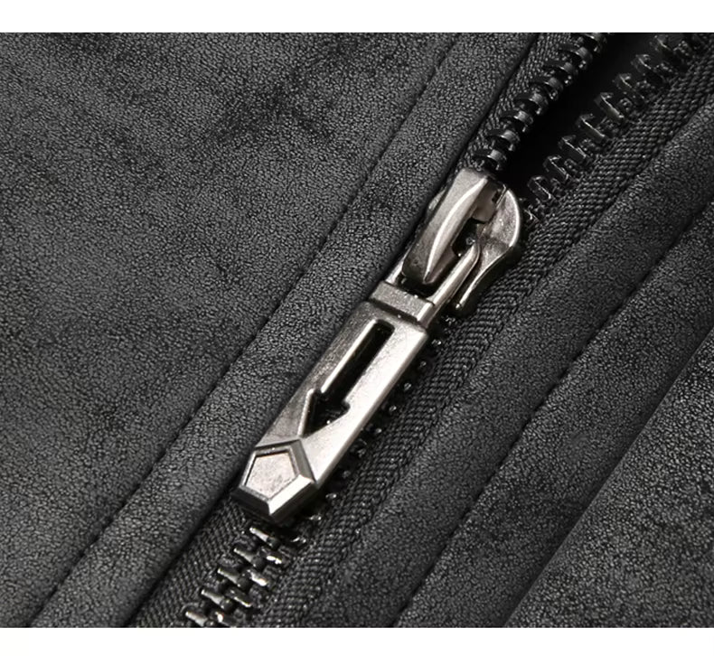 Close-up of a black textured fabric zipper with a metallic silver pull tab.