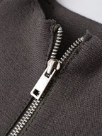 Close-up of a dark charcoal gray ribbed knit garment with a silver metal zipper.