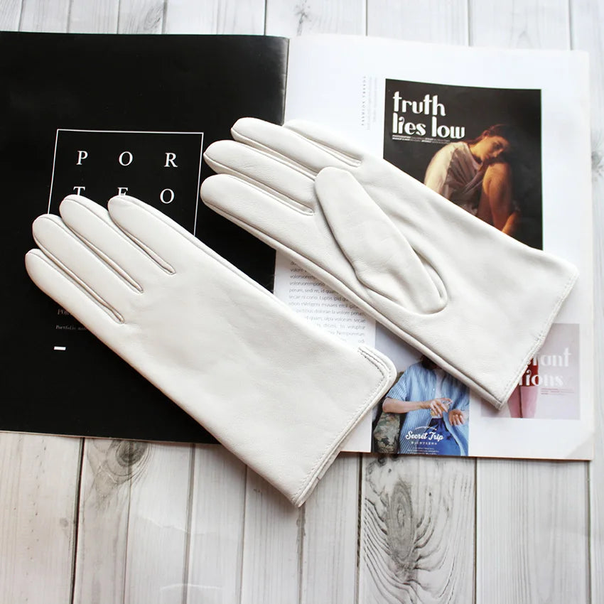 White gloves on top of a magazine with visible text and images.