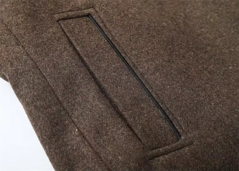 Close-up of a brown wool or felt fabric surface with a rectangular stitched pocket or welt detail.