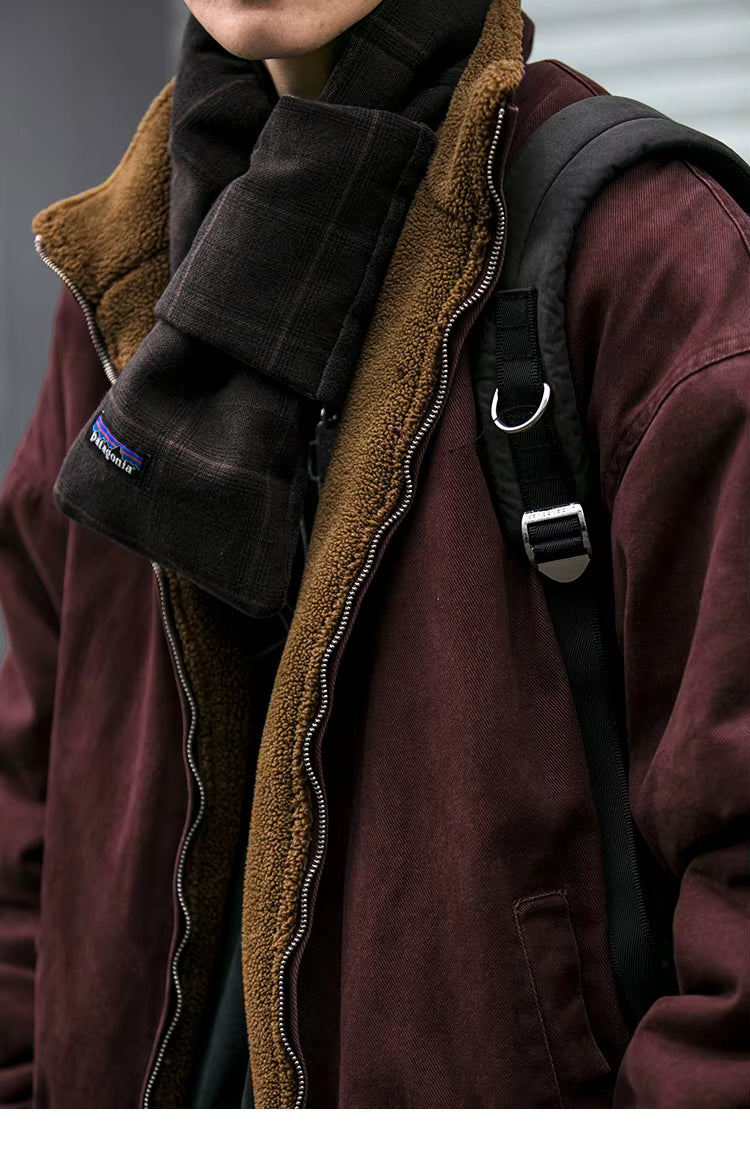 Person wearing a maroon jacket with brown lining and a black backpack, featuring a Patagonia logo.