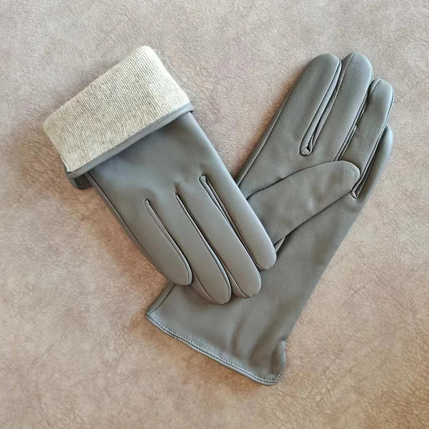 Pair of gray gloves with a textured cuff on a beige surface