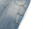 Close-up of light blue denim jeans showing the back pocket and fabric texture on a white background.