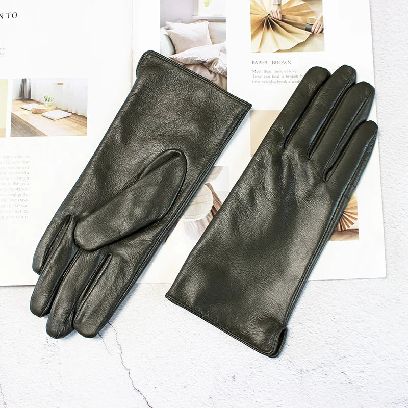 Pair of dark green leather gloves on a light background