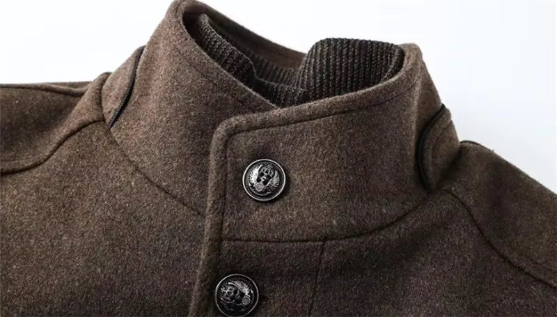 Close-up of a brown wool-like coat with a high ribbed collar and dark decorative buttons, shown against a plain light background.
