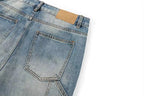 Close-up of the back waistband and pocket area of light blue denim jeans on a white background, showing a tan leather patch near the waistband.
