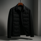 A black men's quilted jacket with a collar and snap-button front, hanging on a wooden hanger against a dark gray studio background.