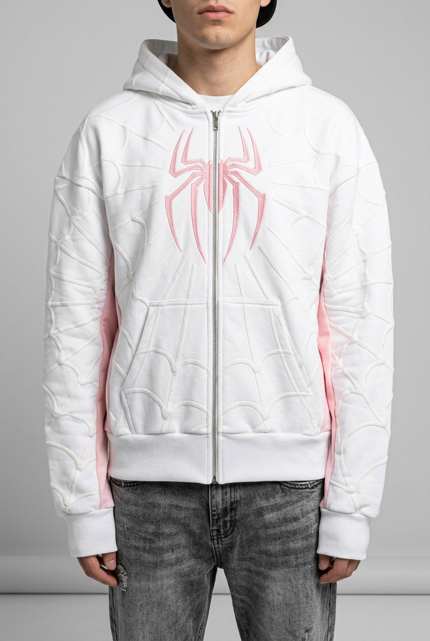 Person wearing a white hoodie with pink design outdoors