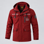 Red jacket with multiple pockets and zippers on a blurred snowy background