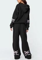 Black hoodie and pants set with white logo on a white background