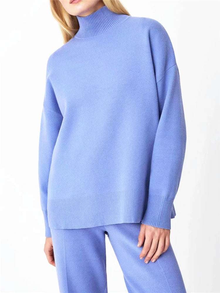 Person wearing a light blue sweater and pants on a white background