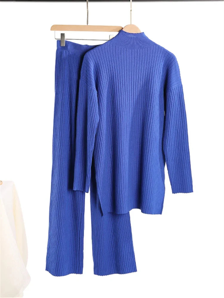 Blue ribbed sweater and pants set on a hanger against a white background