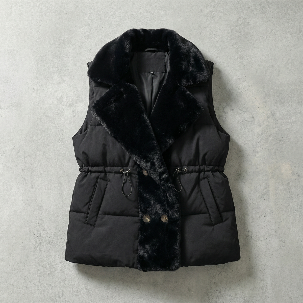 Black puffer vest with fur collar on a light gray background