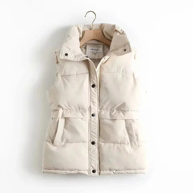 Beige puffer vest on a hanger against a white background