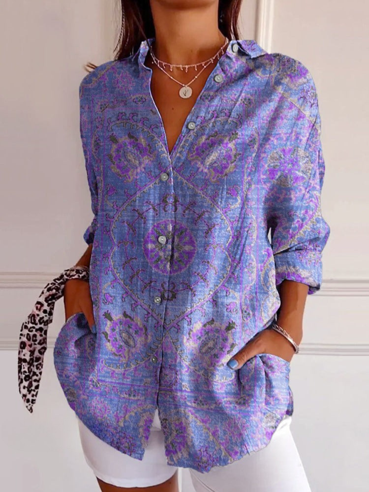 Person wearing a purple patterned shirt with a white background