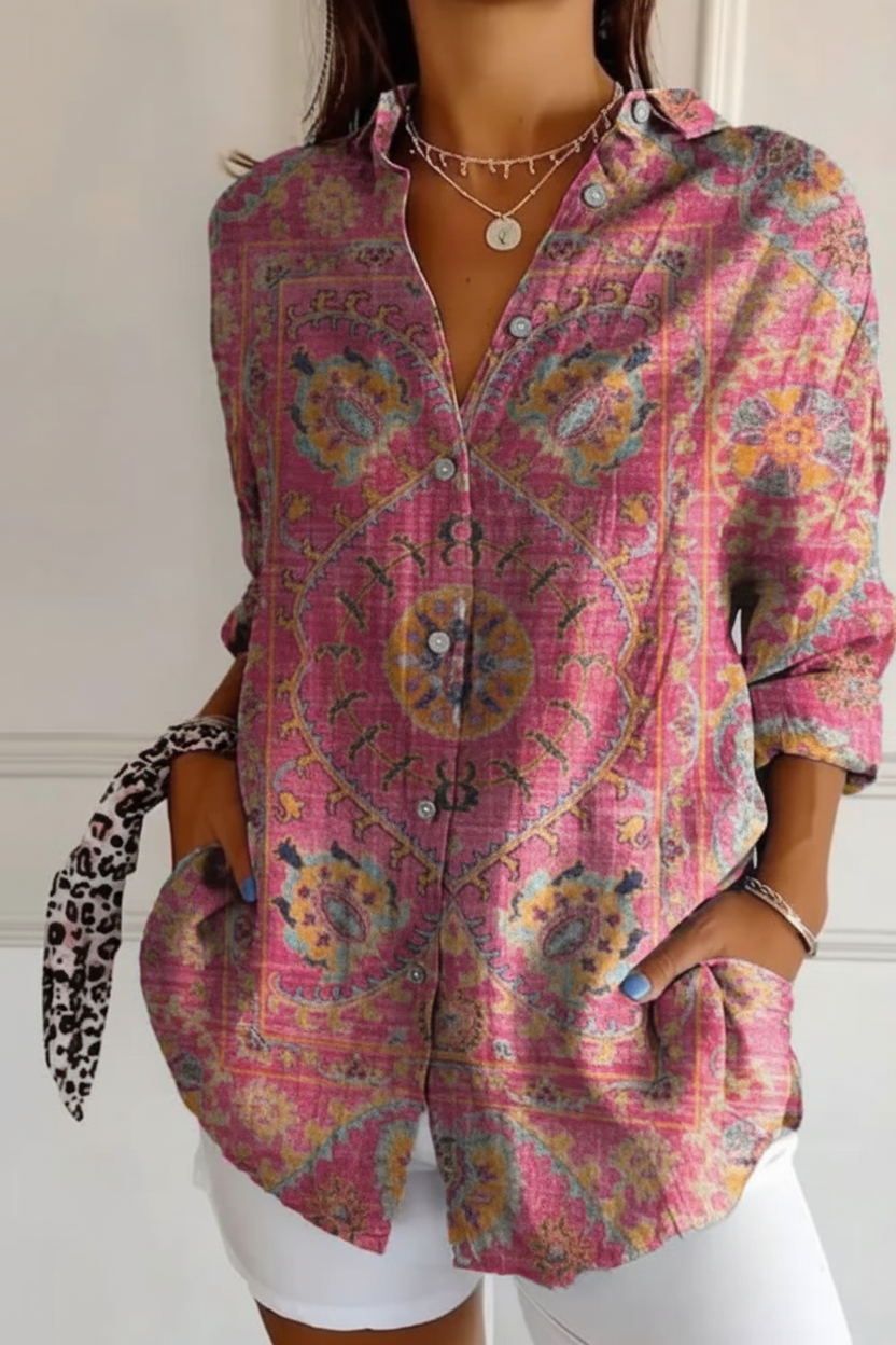 Person wearing a colorful patterned shirt with a neutral background