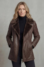 Woman wearing a brown leather coat with fur collar against a plain background