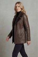 Woman wearing a brown leather coat against a plain background
