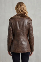 Brown leather jacket with fur collar worn by a person on a gray background