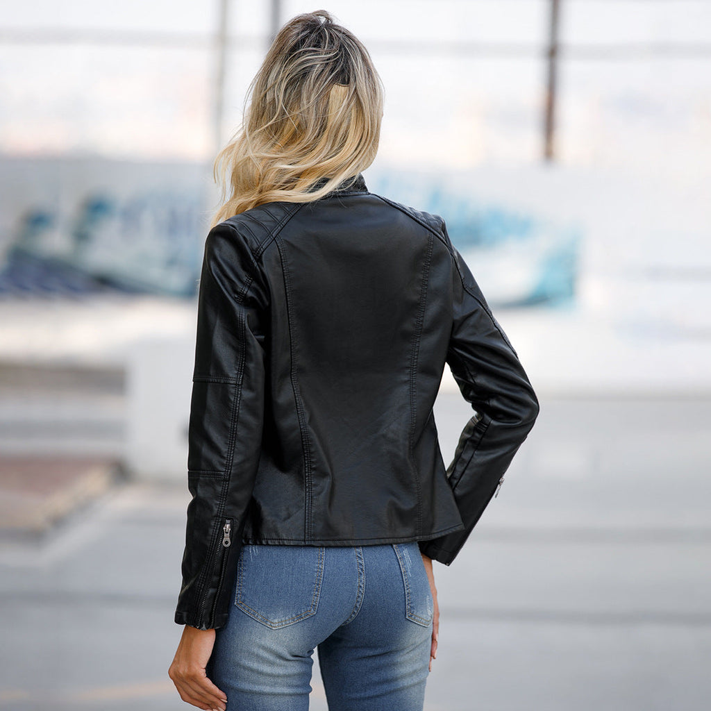 Person wearing a black leather jacket and blue jeans with a blurred background