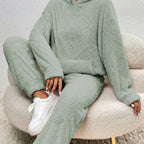 Person wearing a green fleece outfit sitting on a textured chair.