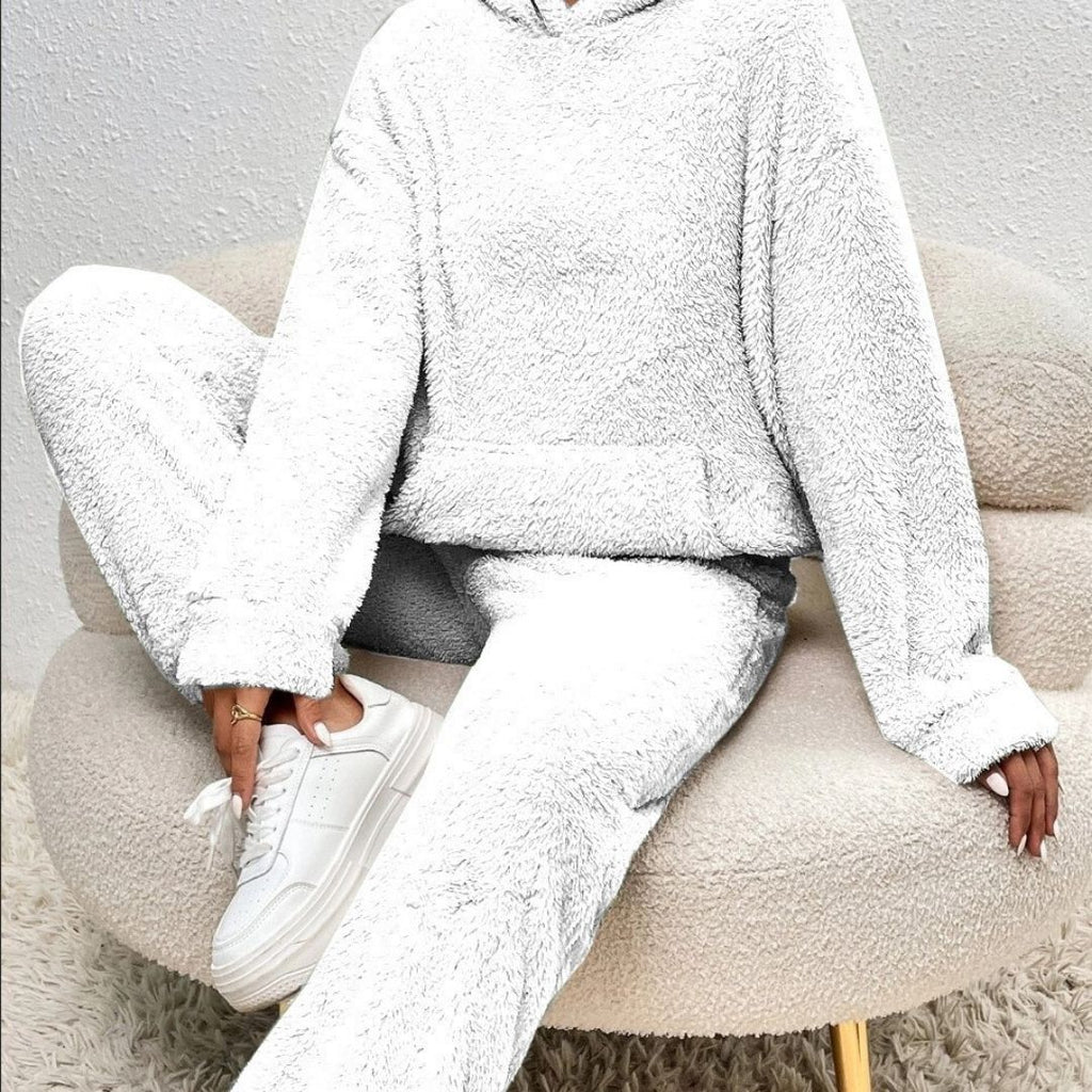Person wearing a white fleece outfit sitting on a beige chair.