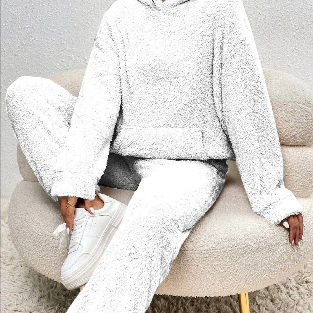 Person wearing a white fleece outfit sitting on a beige chair.