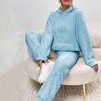 Person wearing a light blue fleece outfit sitting on a white chair.