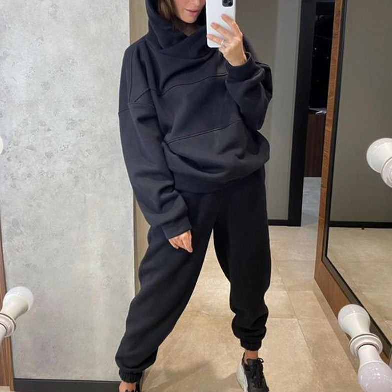 Person wearing a black hoodie and pants in front of a mirror.