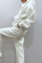 White hoodie and pants set on a plain background