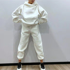 Person wearing a white tracksuit against a plain background