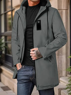 Person wearing a gray jacket with a black shirt and jeans, standing outdoors.