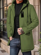 Person wearing a green jacket with a black shirt and jeans, standing outdoors.