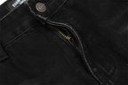 Close-up of a black denim jacket with a zipper and button detail.