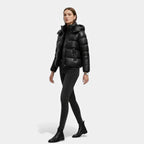 Woman wearing a black puffer jacket on a white background