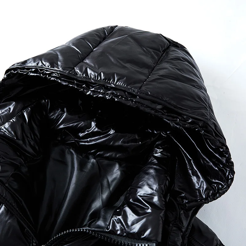 Close-up of a black puffer jacket with shiny surface on a white background
