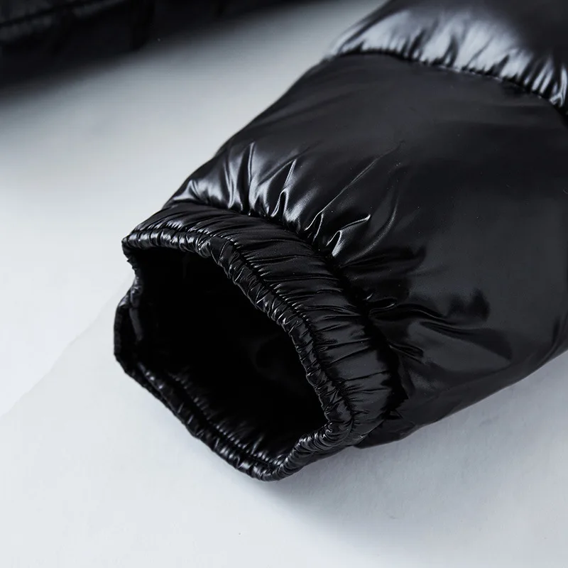 Close-up of a black puffer jacket on a light gray background