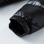 Close-up of a black puffer jacket on a light gray background