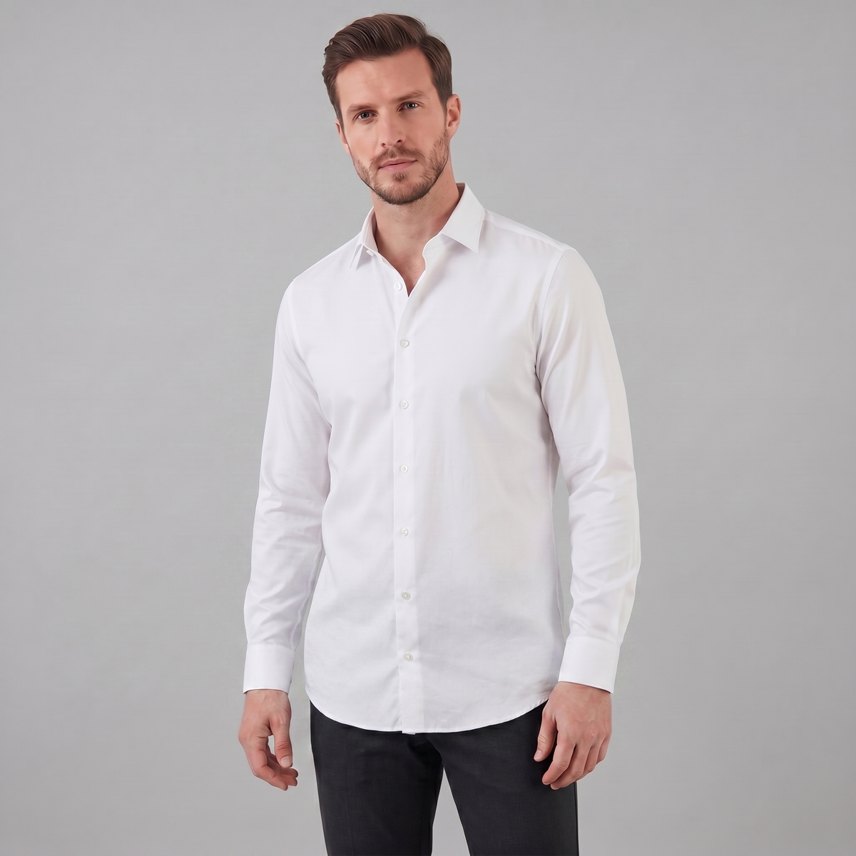 Man wearing a white dress shirt against a gray background