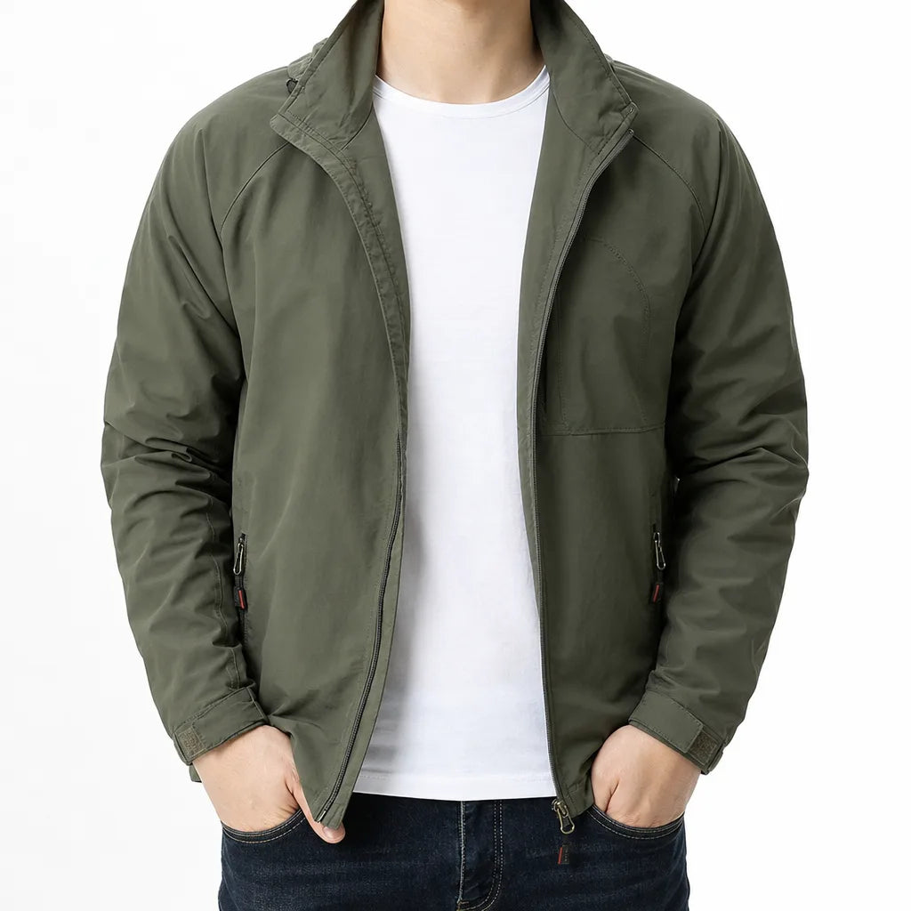 An olive green lightweight jacket worn by a model over a white t-shirt and dark blue jeans, shown from the neck down against a plain white background.