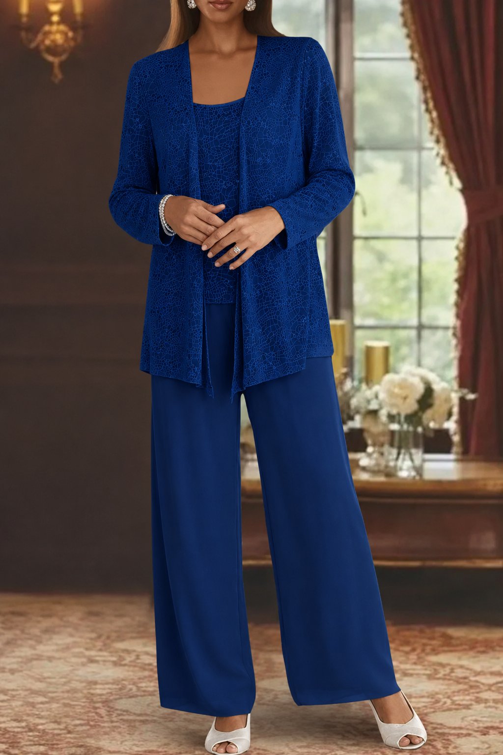 Woman wearing a blue outfit in an elegant room with a window and decorative items.